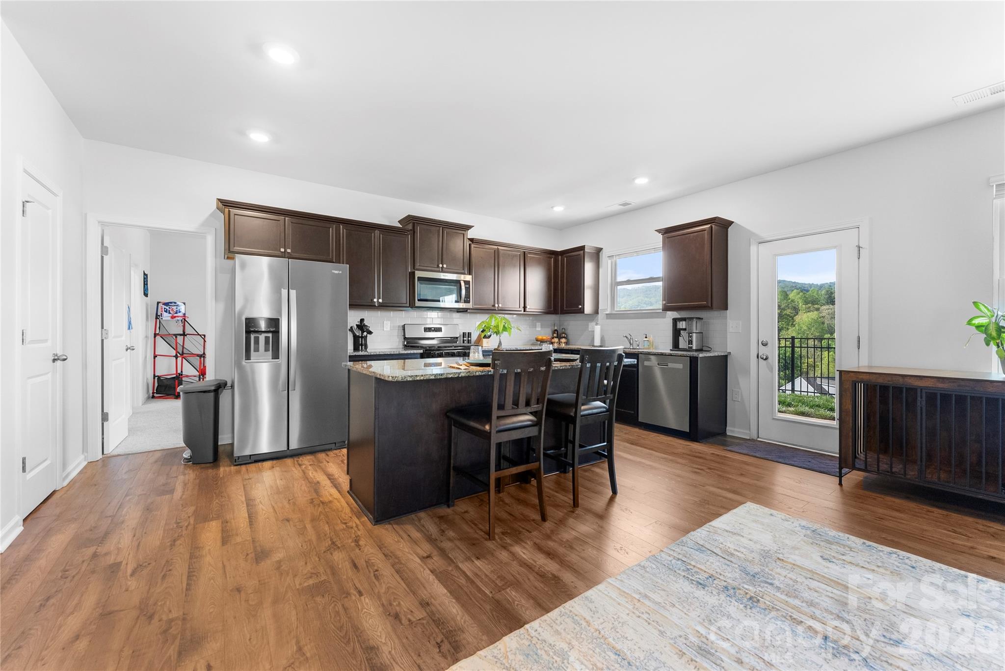 141 Amblers Knl Road Weaverville, NC 28787 - Photo 8 of 48 a kitchen with stainless steel appliances a refrigerator a stove a sink dishwasher and a dining table with wooden floor
