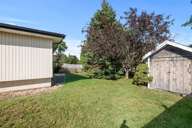 a backyard of a house with a garden and tree