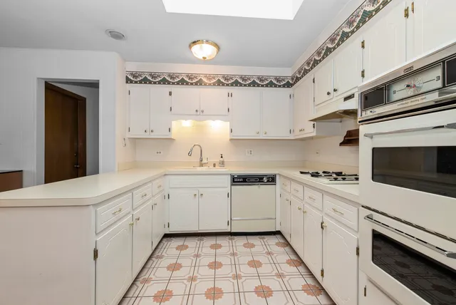 a kitchen with granite countertop white cabinets and white appliances