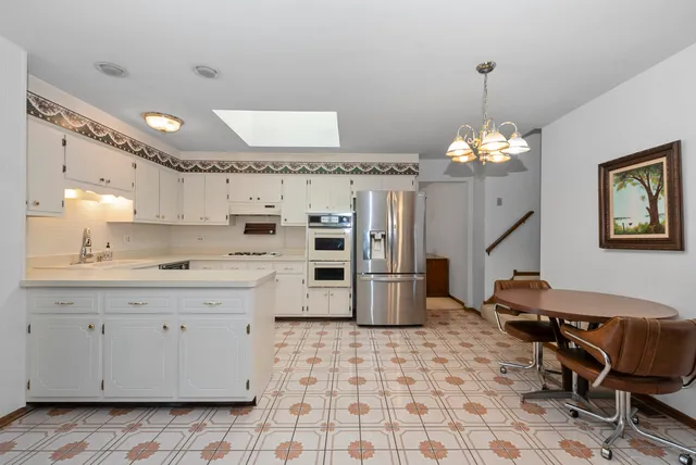 a kitchen with granite countertop a sink a stove a refrigerator and a stove