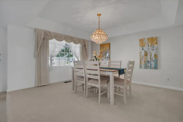 a dining room with furniture a chandelier and window