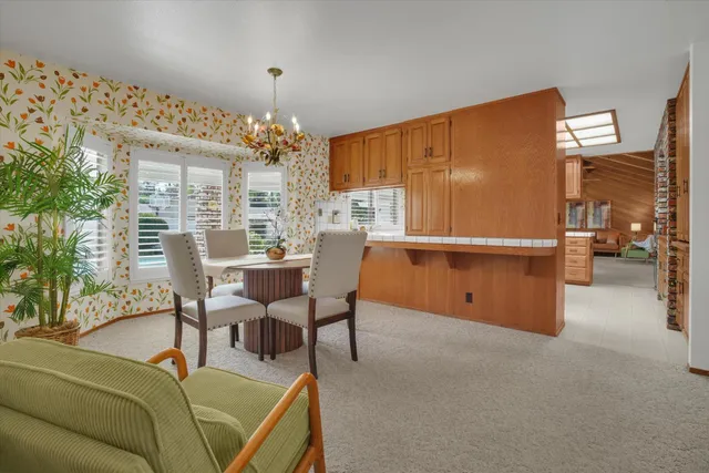 a living room with furniture a chandelier and a dining table