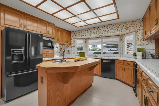 a kitchen with stainless steel appliances granite countertop a stove a refrigerator and a sink