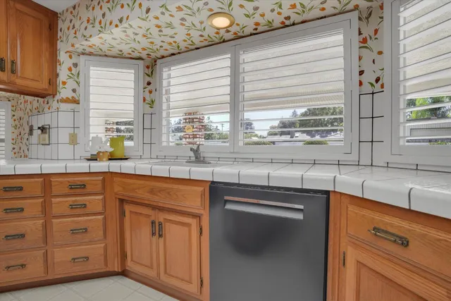 a kitchen with stainless steel appliances white cabinets and a window