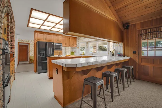 a dining hall with stainless steel appliances a sink stove and table chair