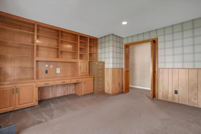 a view of an empty room with cabinet and a window