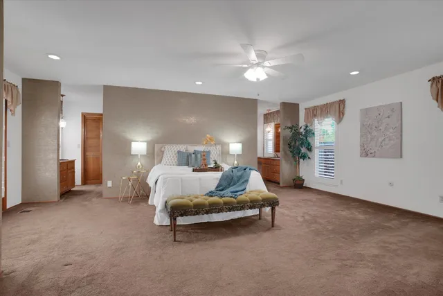 a spacious bedroom with a bed and lamp