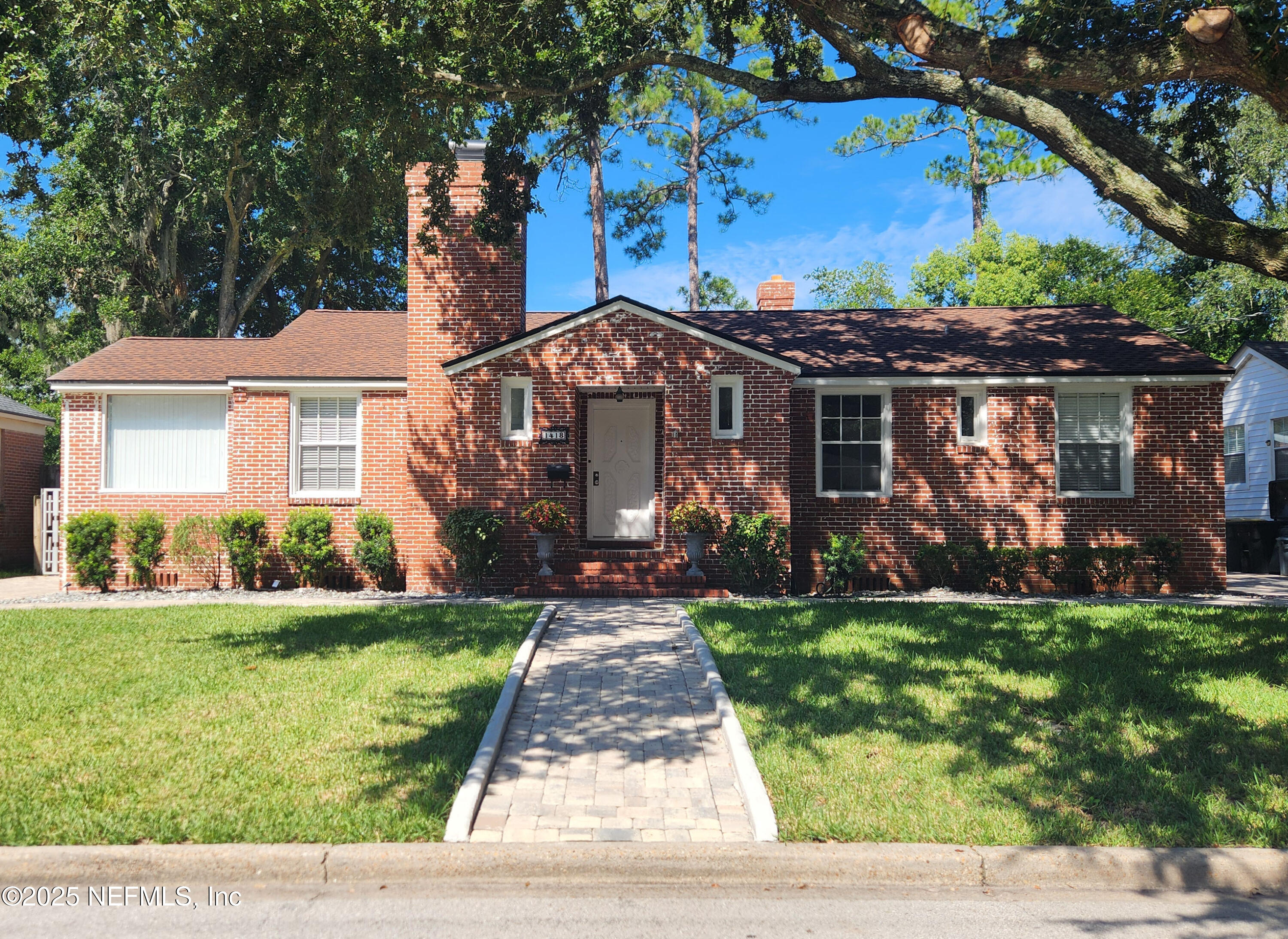 a front view of a house with a garden