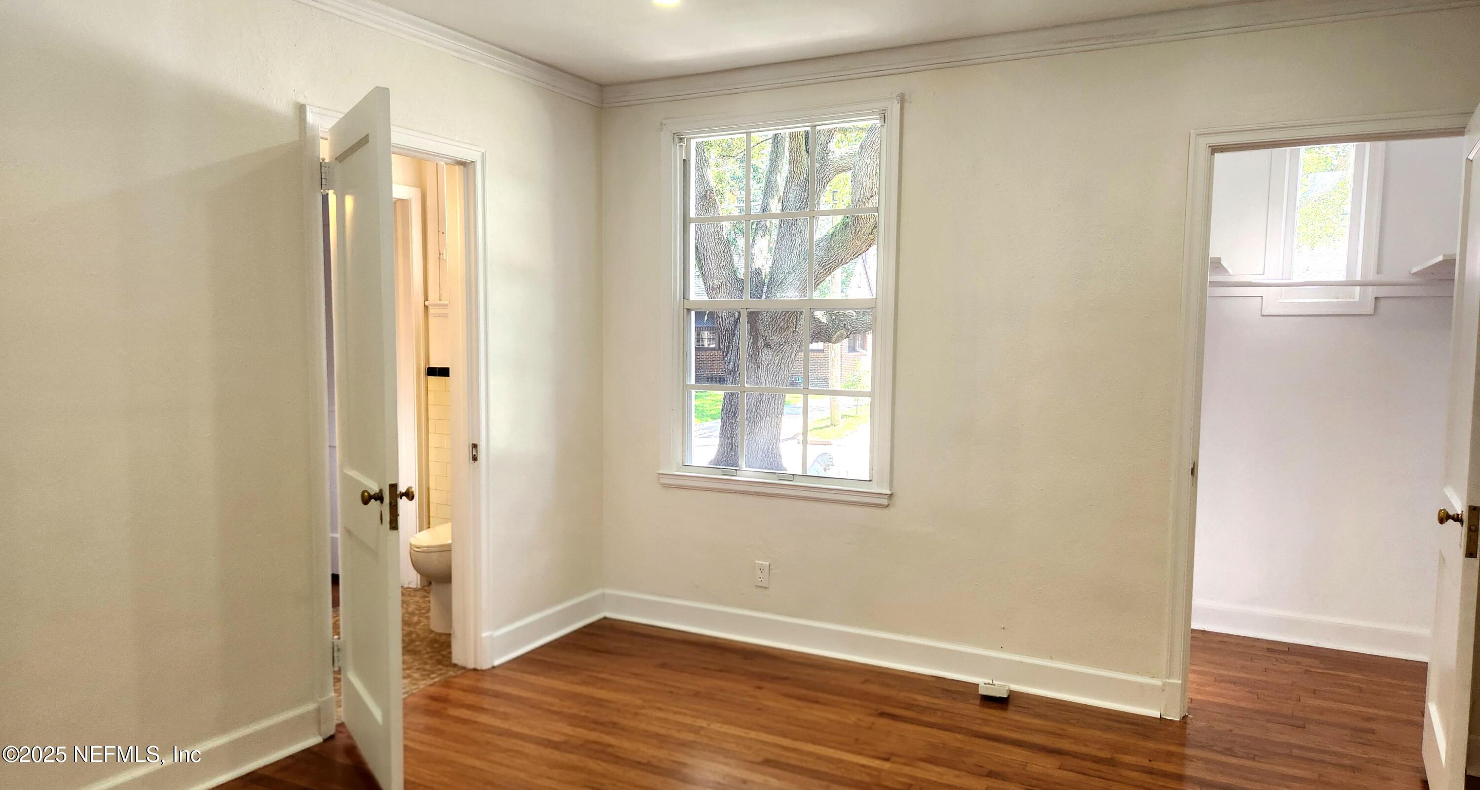 1418 Nicholson Road Jacksonville, FL 32207 - Photo 12 of 35 a view of an empty room with wooden floor and a window