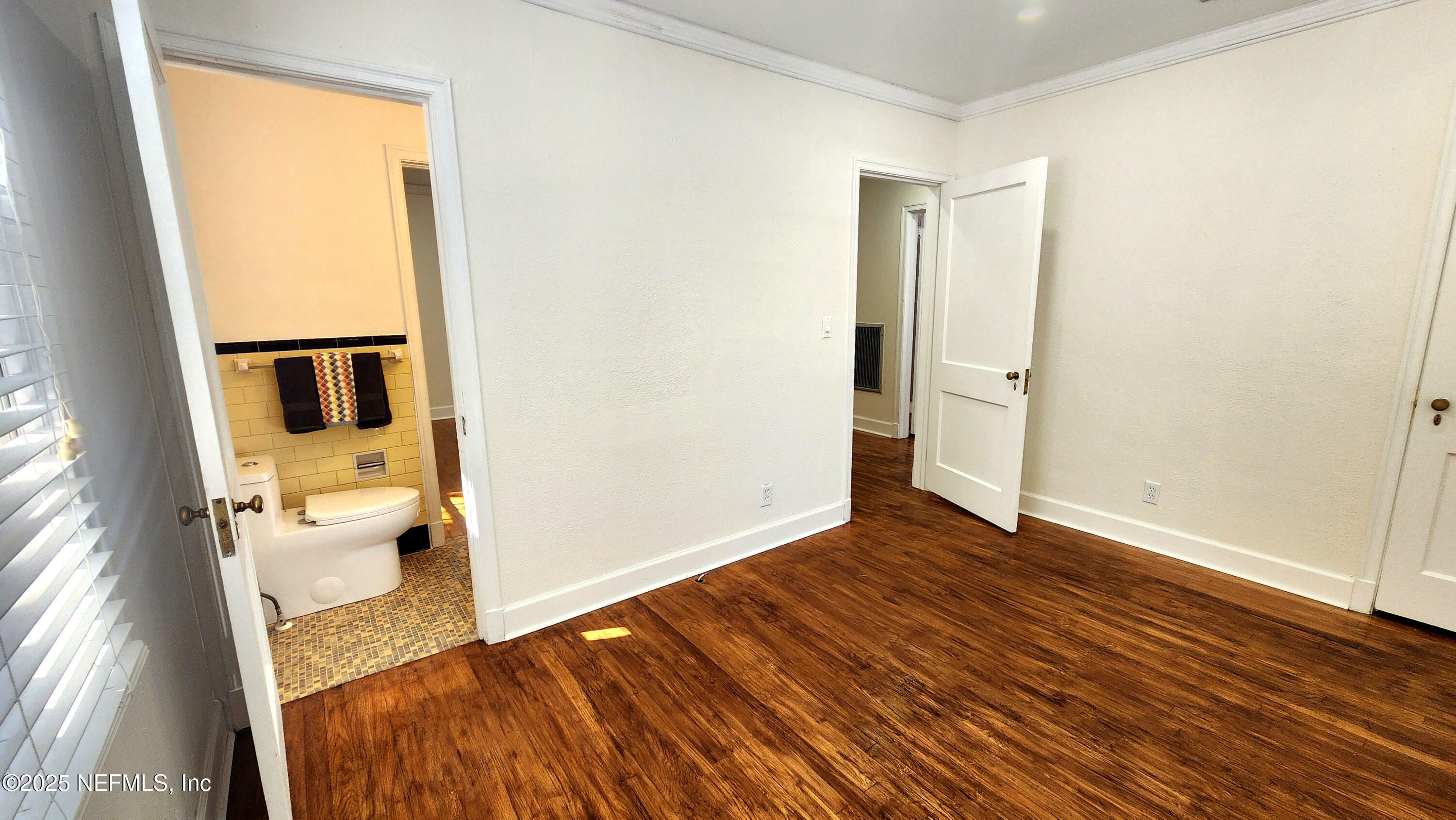 1418 Nicholson Road Jacksonville, FL 32207 - Photo 19 of 35 a view of walk in closet with wooden floor and a bathroom