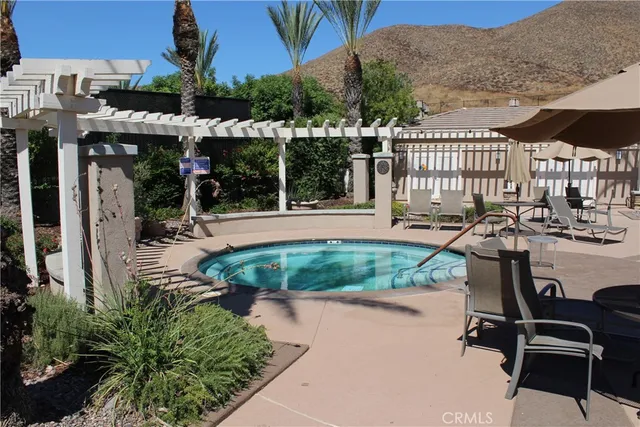 a view of a swimming pool with lawn chairs and a patio