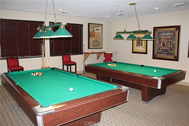 a room with pool table and windows