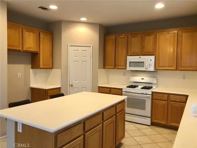 a kitchen with stainless steel appliances granite countertop a stove a sink dishwasher and a refrigerator