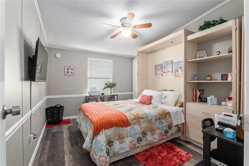 1727 Hilton Head Boulevard Lady Lake, FL 32159 - Photo 24 of 39 a bedroom with a bed a flat screen tv and a chandelier