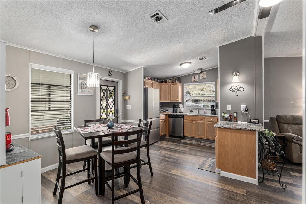 1727 Hilton Head Boulevard Lady Lake, FL 32159 - Photo 4 of 39 a dining room with a table chairs and kitchen view