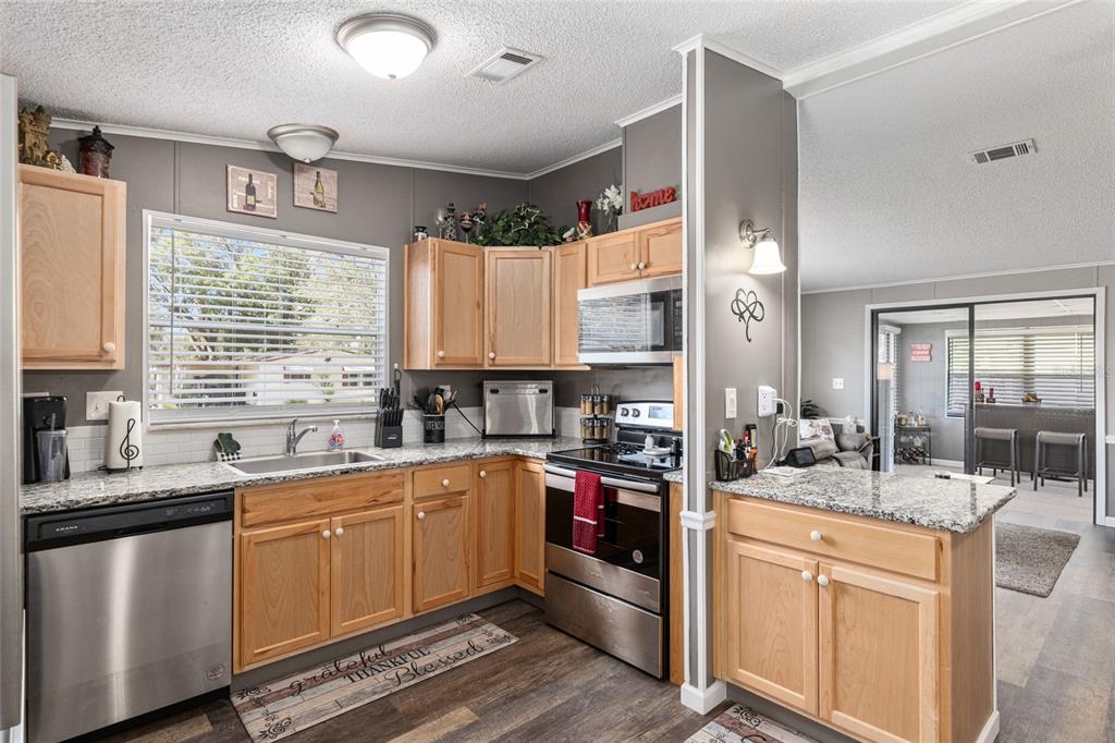1727 Hilton Head Boulevard Lady Lake, FL 32159 - Photo 5 of 39 a kitchen with a sink stove top oven and cabinets