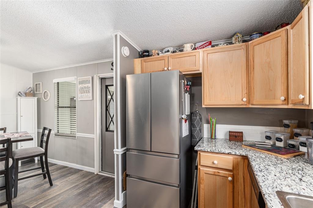 1727 Hilton Head Boulevard Lady Lake, FL 32159 - Photo 9 of 39 a kitchen with stainless steel appliances granite countertop a refrigerator and a stove top oven