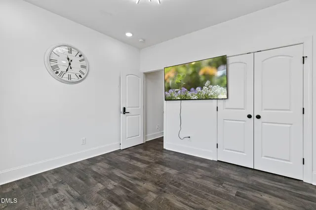 a view of an empty room with wooden floor