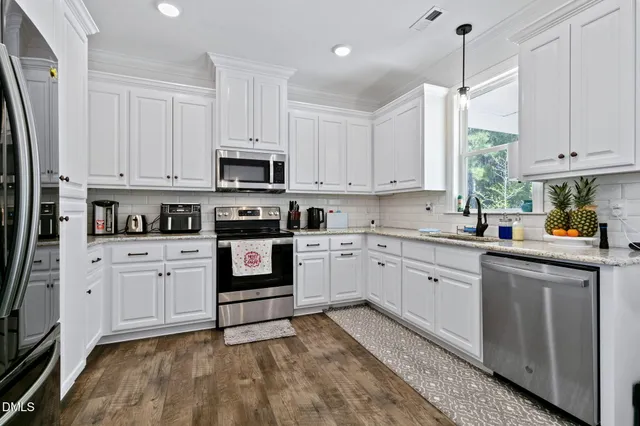a kitchen with granite countertop white cabinets and white appliances