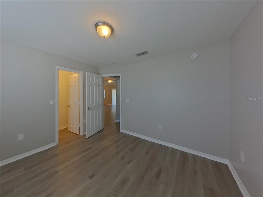 Undisclosed Address Davenport, FL 33837 - Photo 11 of 17 a view of an empty room with wooden floor and window