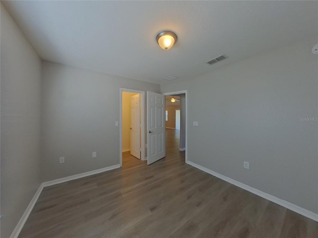 Undisclosed Address Davenport, FL 33837 - Photo 12 of 17 a view of an empty room with wooden floor and windows