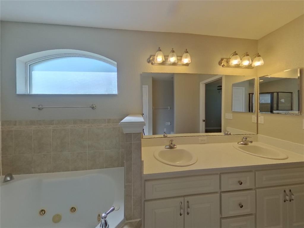 Undisclosed Address Davenport, FL 33837 - Photo 9 of 17 a bathroom with a sink a large mirror and a bathtub