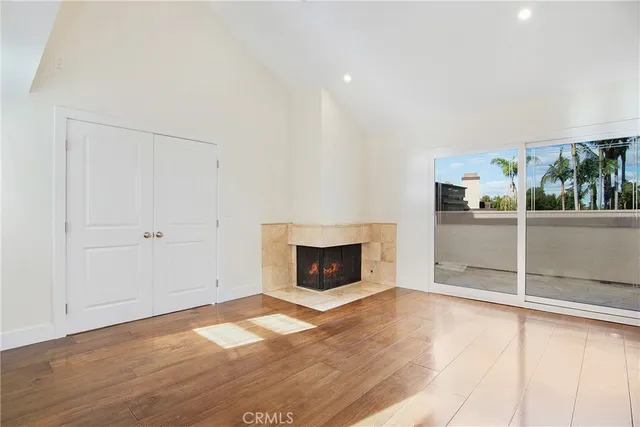 a view of a livingroom with wooden floor a fireplace and window