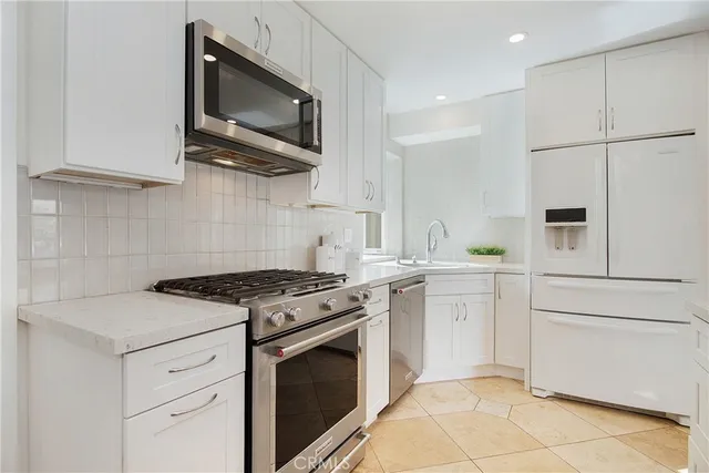 a kitchen with granite countertop cabinets stainless steel appliances and a sink