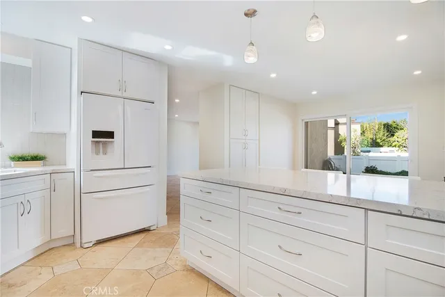 a kitchen with white cabinets and refrigerator