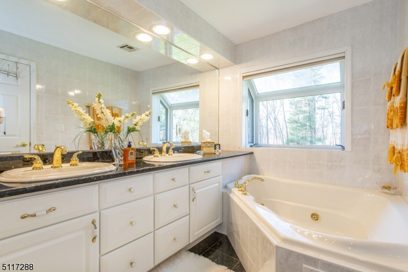 5 Spring Lane Warren, NJ 07059 - Photo 18 of 31 a bathroom with a tub a sink a large mirror and vanity