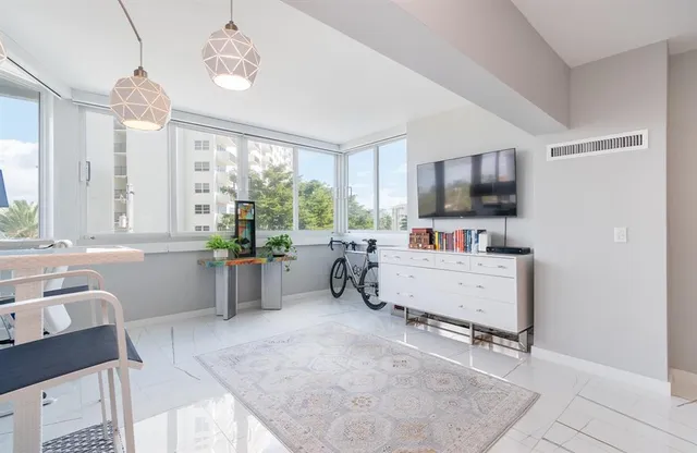 a room with furniture a flat screen tv and a window