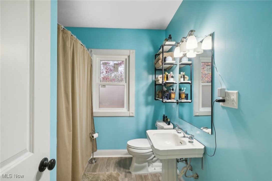 7995 Johnnycake Ridge Road Mentor, OH 44060 - Photo 15 of 47 Bathroom featuring toilet, hardwood / wood-style floors, and curtained shower