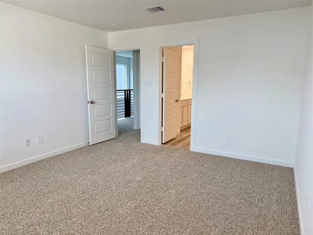 an empty room with a window and a kitchen