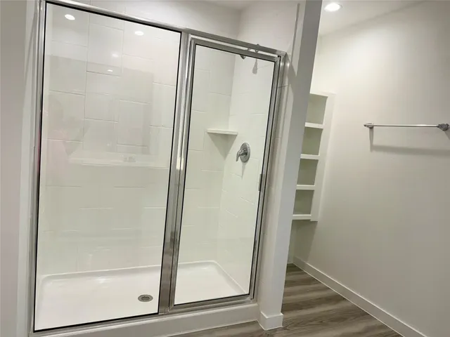 a bathroom with a glass shower door and a glass door
