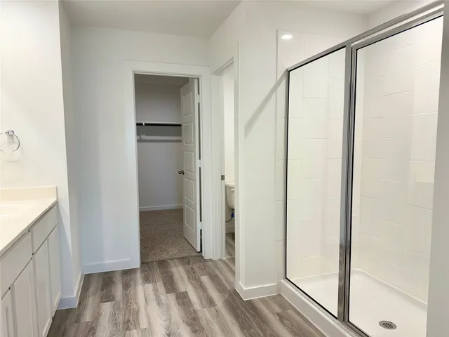 a view of hallway with closet and wooden floor