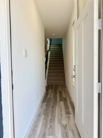 a view of a hallway with wooden floor and entryway