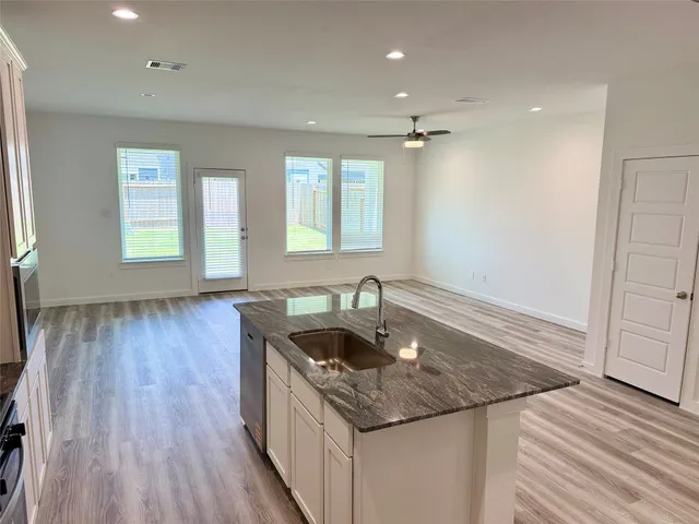 a kitchen with granite countertop a sink and a stove top oven