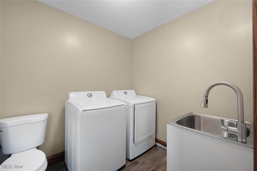 11794 Vermilion Road Oberlin, OH 44074 - Photo 15 of 34 Clothes washing area featuring washer and clothes dryer, baseboards, a sink, dark wood-style floors, and laundry area