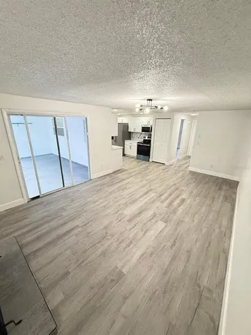 a view of a kitchen with furniture and wooden floor
