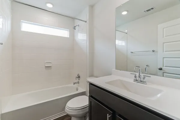 a bathroom with a granite countertop sink a toilet and shower
