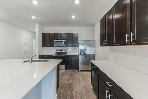 a kitchen with kitchen island granite countertop stainless steel appliances stove a sink and a microwave