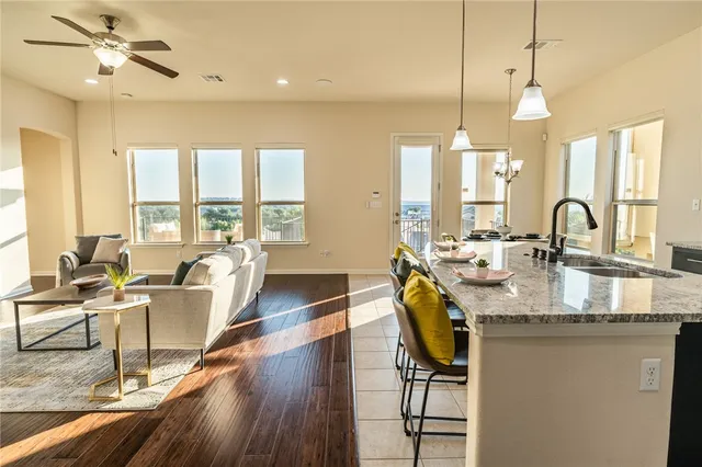 a living room with granite countertop furniture a dining table with wooden floor and a chandelier