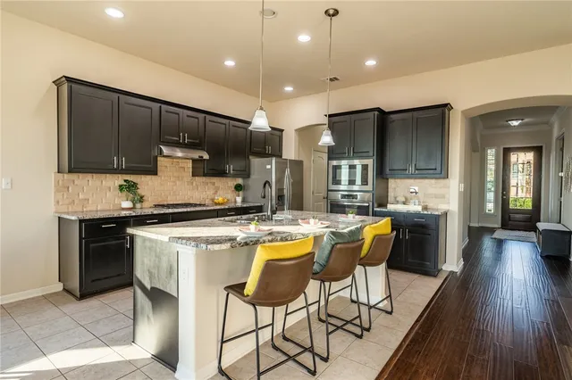 a kitchen with a sink a counter top space stainless steel appliances and cabinets
