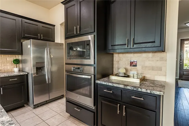 a kitchen with granite countertop stainless steel appliances and wooden cabinets