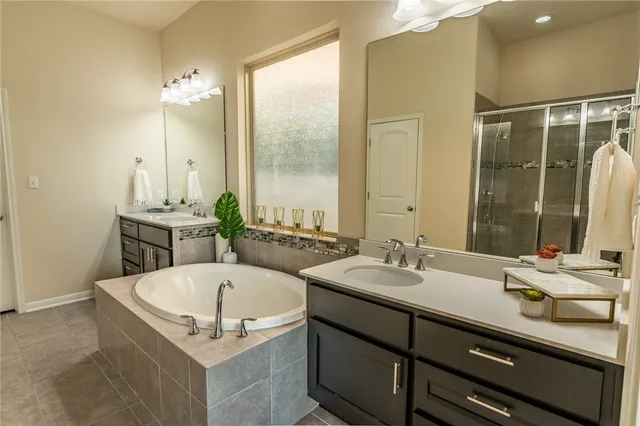 a bathroom with a tub sink and mirror
