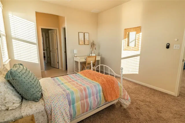 a bedroom with a bed a mirror and a window