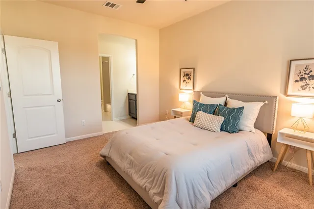 a bedroom with a bed and painting on the wall