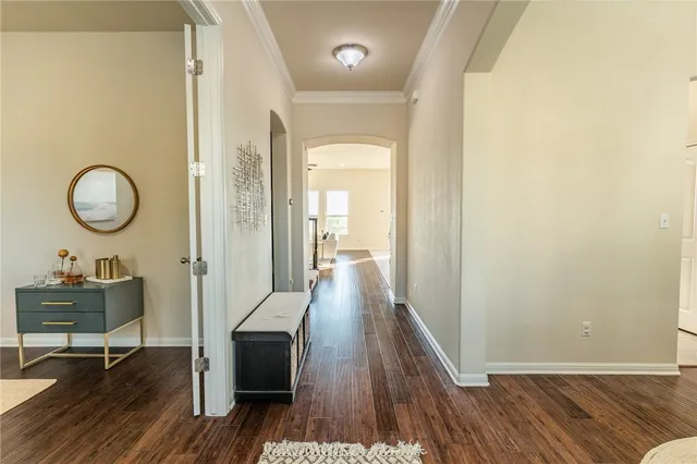 a view of a hallway with wooden floor table and chairs