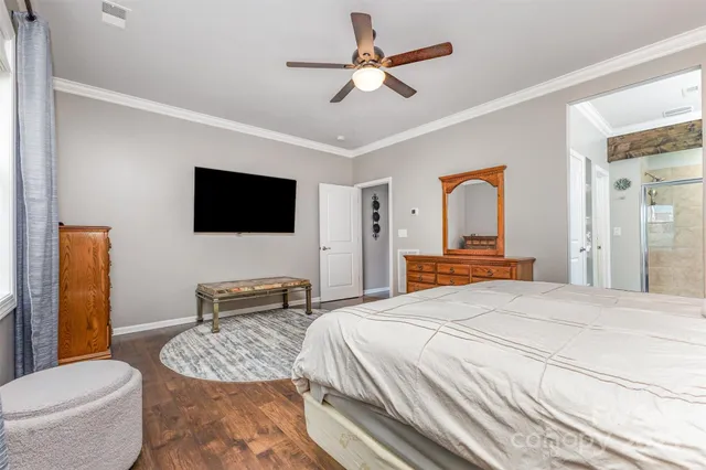 a bedroom with a bed a flat screen tv and a couch