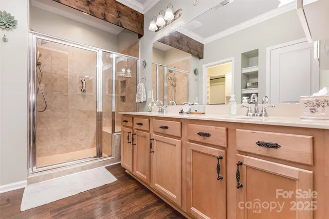 a bathroom with a double vanity sink a mirror a shower and a bathtub